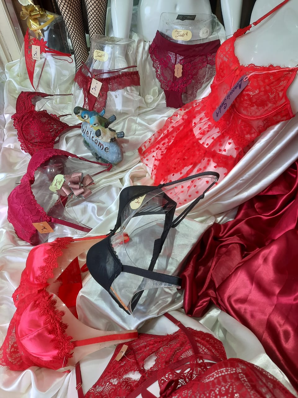 Maniquíes con prendas y bolsas de regalo de la boutique